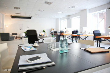 Office interior with bottles of water and documents on table. Workplace design