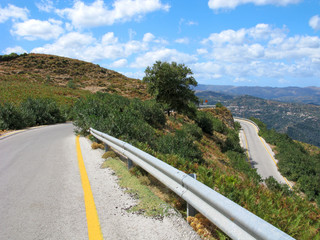 Crete, Greece. Sharp turn of road in mountains. Yellow marking of roadsides is used on roads, on which snow can be in winter.