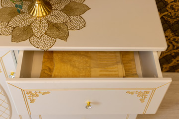 Yellow beautiful towel in a chest of drawers with gold inserts.