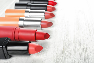 Collection of lipsticks on white wooden background