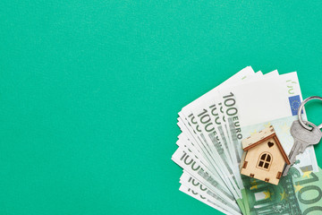 Toy house, key and euro banknotes