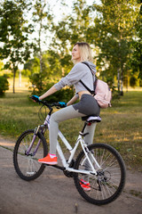 Fototapeta na wymiar young woman in a hat with a bike in the park. Active people. Outdoors
