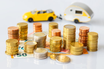 Euro coins in pile on Euro banknotes with car and caravan, save money for a trip. Germany