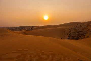Fototapeta na wymiar Sunset and amazing landscape of Red Sand Dunes in south Vietnam near to Mui Ne fishing town.