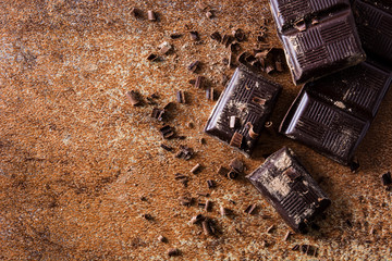 Chocolate pieces on brown background. Top view. Copyspace