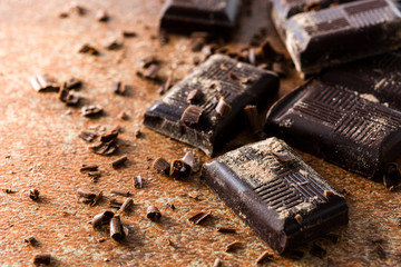 Chocolate pieces on brown background. Copyspace