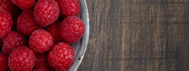 Banner of fresh ripe raspberries. Fresh raspberries on the wooden background. Concept banners and postcards Copy space. Top view. Harvest Concept. Wabi sabi style.