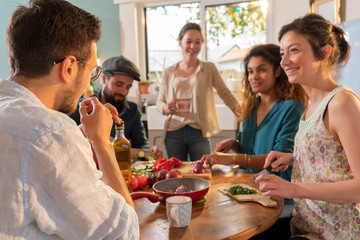 Multi-ethnic group of friends cooking lunch in the kitchen. 