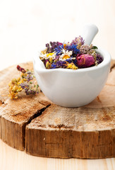 Medicinal herbs and flowers in a glass mortar. Herbal medicine, health, healing