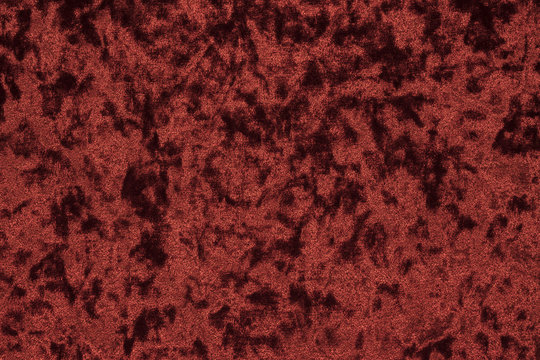 Highly detailed texture background of a red or wine color velour cloth characterized by its lush, plush surface composed of densely packed and closely woven fibers that showcases a luxurious feel.