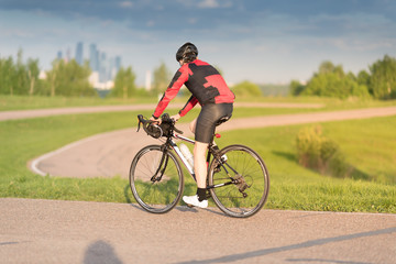 Fototapeta na wymiar A cyclist in helmet riding a bike on a special asphalt velo road