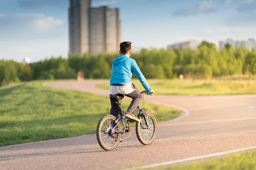 Obraz premium Happy boy ride a bicycle in city park