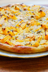 Pizza with pumpkin on wooden background