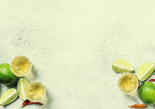Gold mexican tequila with lime and salt, white drink background, top view