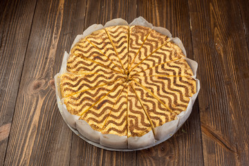 Dark chocolate vegan cake with candies and nuts on wooden background