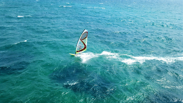 Aerial drone bird's eye view of surfer in tropical clear water beach