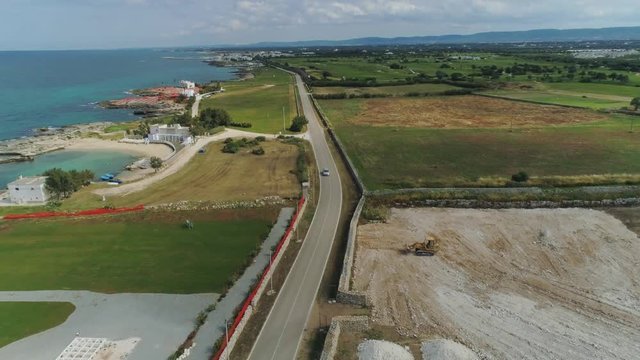 Car drive through the field near the sea in Italy Drone flight 4k