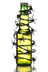 Green beer bottle wrapped in barbwire on white isolated background. Stop alcoholism. Drink responsibly. Drink aware,