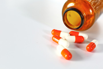 Colored pills poured from a brown bottle. Medical concept