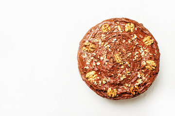 Homemade chocolate cake with nuts, white background, top view