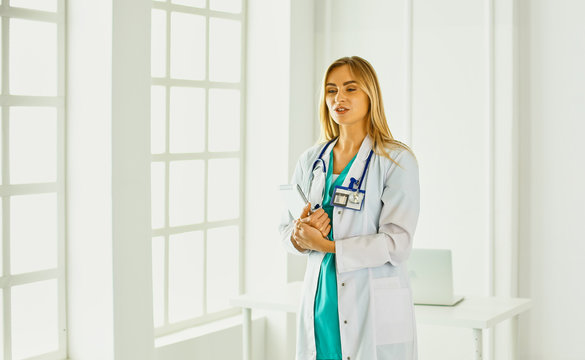 An attractive female doctor is standing in the office, selective focus
