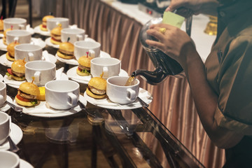 Blurred for Background.The waitress filed a glass of white coffee with the Egg tart,Hamburger between the brake and the brake food background.
