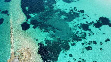Aerial drone bird's eye view of iconic temple of Apollo on top of Kolona hill with only one pillar left standing, Aigina island, Saronic gulf, Greece
