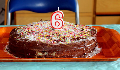 Deliciosa tarta de chocolate para cumpleaños con el número seis como vela