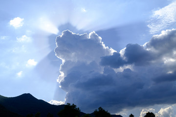 The rays of the sun in the sky shining from behind the clouds 2