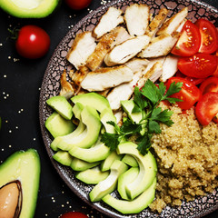 Healthy food, avocado, quinoa, chicken and tomatoes on plate, top view