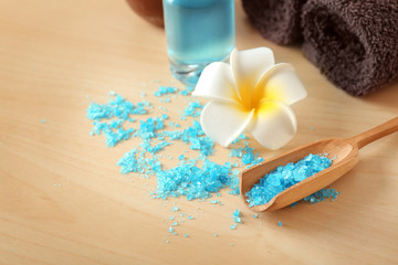 Scoop with sea salt for spa treatment on wooden table