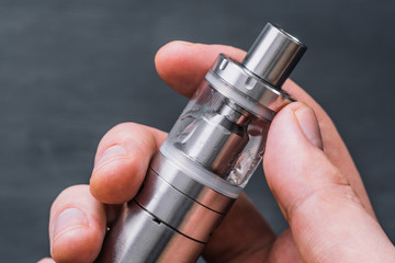 Vape young man vape electronic cigarette cloud by using a mod, smoke tricks of vaping device...
