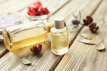 Bottles with essential oils on wooden background