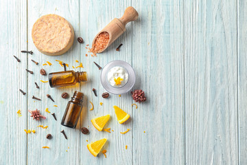 Composition with essential oils on wooden background, top view