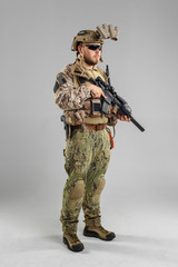Special forces soldier with rifle on white background.