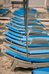 empty chaise lounges and umbrellas at beach