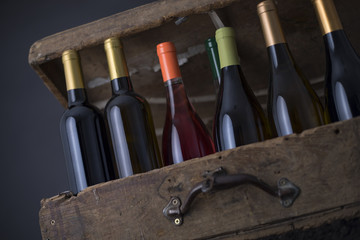 Group of Wine bottle on a Old wood case on a black Background
