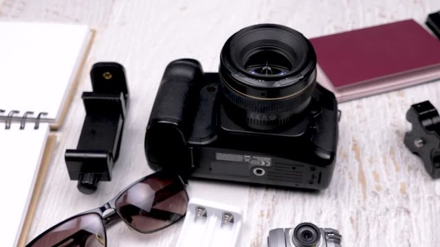 Travel blogger with his camera and other accessories on wooden background