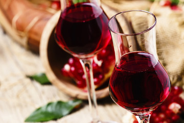 Homemade pomegranate liqueur, still life in rustic style, old wooden background, selective focus