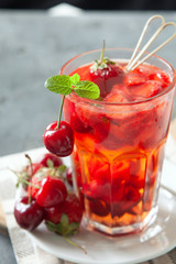 Red compote juice with fresh cherry and strawberry