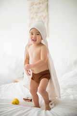 Little boy with hooded towel in bed