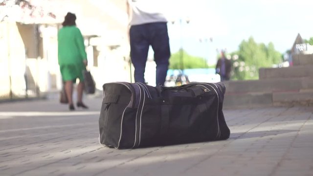 unrecognizable man a terrorist leaves a bomb bag on the street