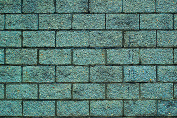 The texture of the greenish brick shabby wall