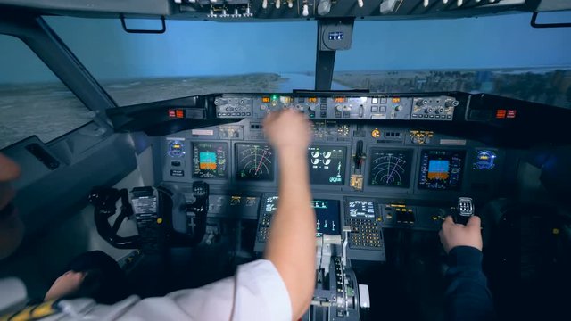 Flight instructor and his trainee are practicing taking off in a flight simulator