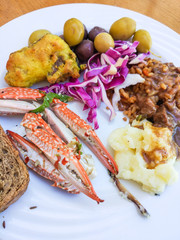 Seafood - big crab with claws on the white plate with garnish. Closeup.