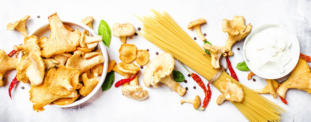 Ingredients for cooking pasta with mushrooms chanterelles in a creamy sauce, food background, top view