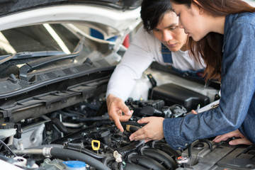 Fototapeta na wymiar A man mechanic and woman customer look at the car hood and discuss repairs.