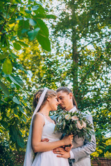 wedding couple. Beautiful bride and groom. Just merried. Close up. Happy bride and groom on their wedding hugging. Groom and Bride in a green garden. wedding dress. Bridal wedding bouquet of flowers