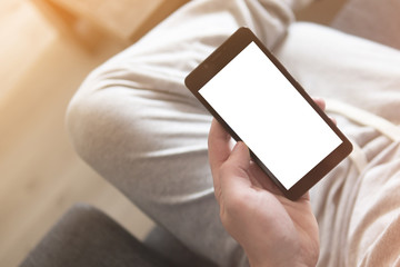 Person holding blank screen mobile phone while sitting