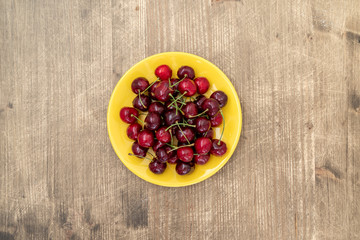 Yellow plate with fresh cherries